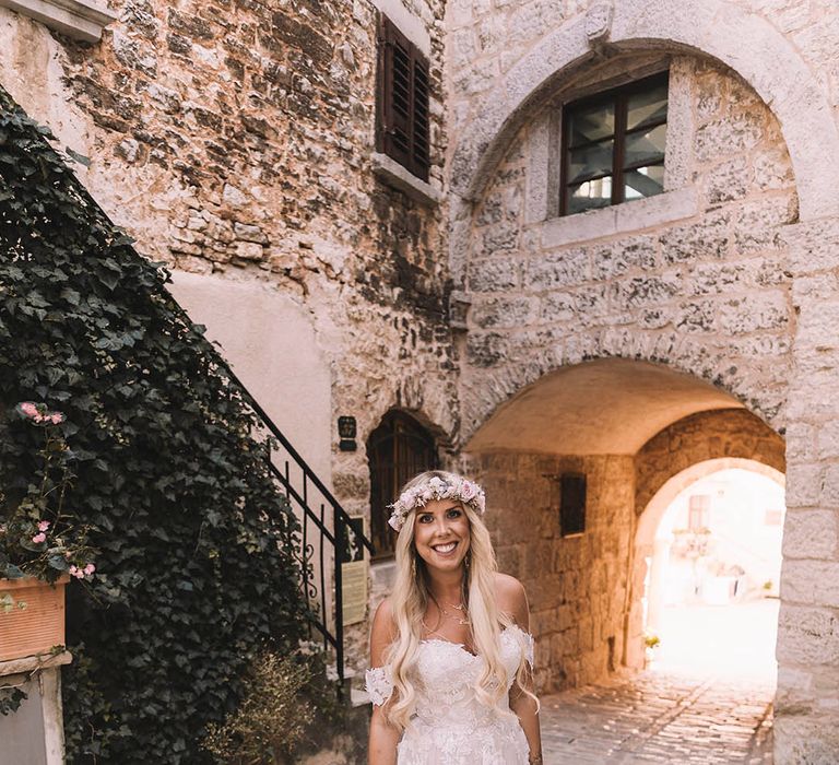 Bride in off the shoulder wedding dress with floral lace design for boho destination wedding 