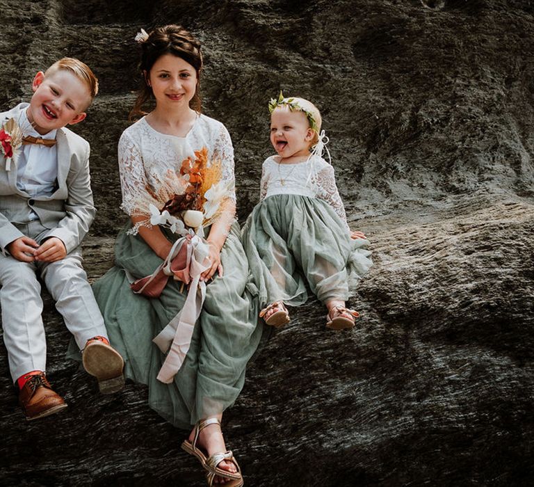 The flower girls and page boys in green, grey and white wedding outfits 