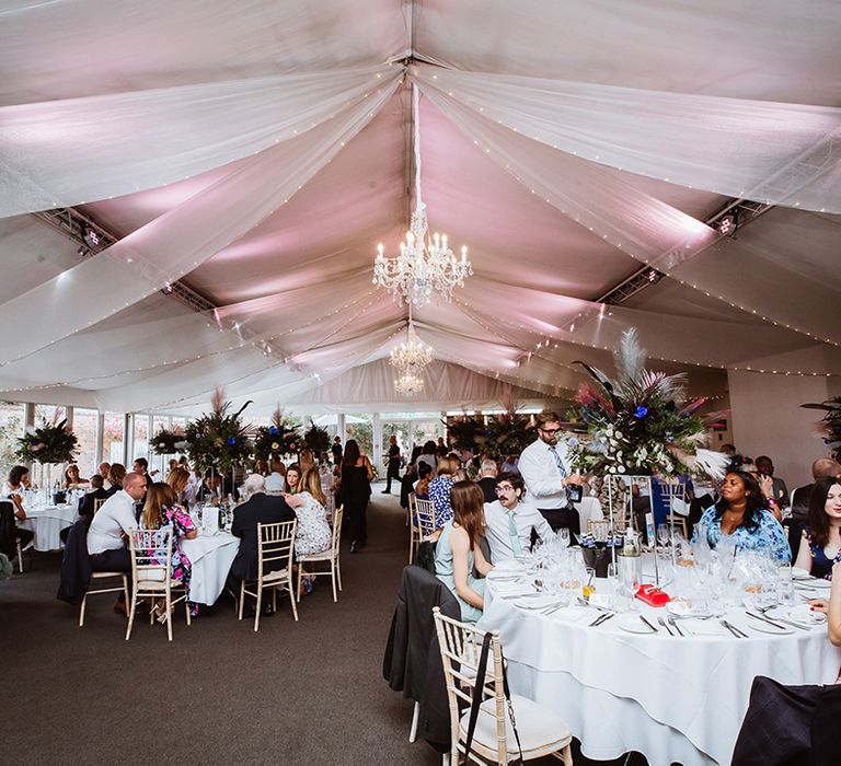 Braxted Park wedding breakfast with minimalist wedding tables decorated with tall table centrepieces 