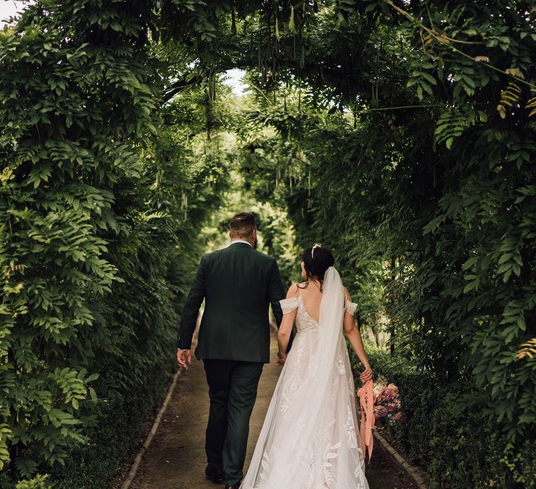 Classic couple portrait of the newlyweds walking hand in hand