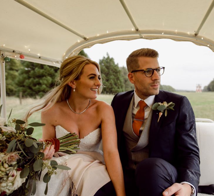 Bride and groom ride on tuk tuk at Larmer Tree Gardens Wedding