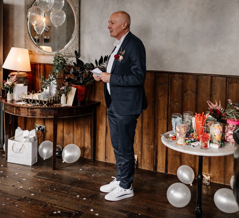 Father of the bride in a navy wedding suit and white trainers 