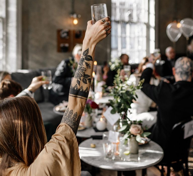 wedding guests raising their glasses at pub wedding reception 