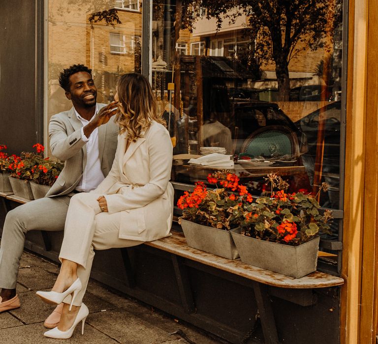 Bride and groom laughing outside their favourite cafe in Portsmouth 