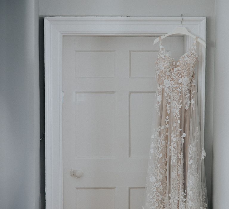 Lace Madi Lane wedding dress hanging up 