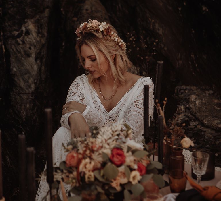 Bohemian bride in lace wedding dress with tassel sleeves with layered necklaces and a flower crown 