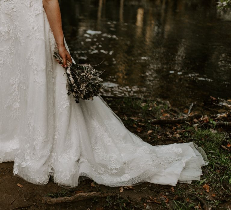 Stunning beaded floral wedding dress with dried flower bouquet and groom in traditional Scottish kilt 