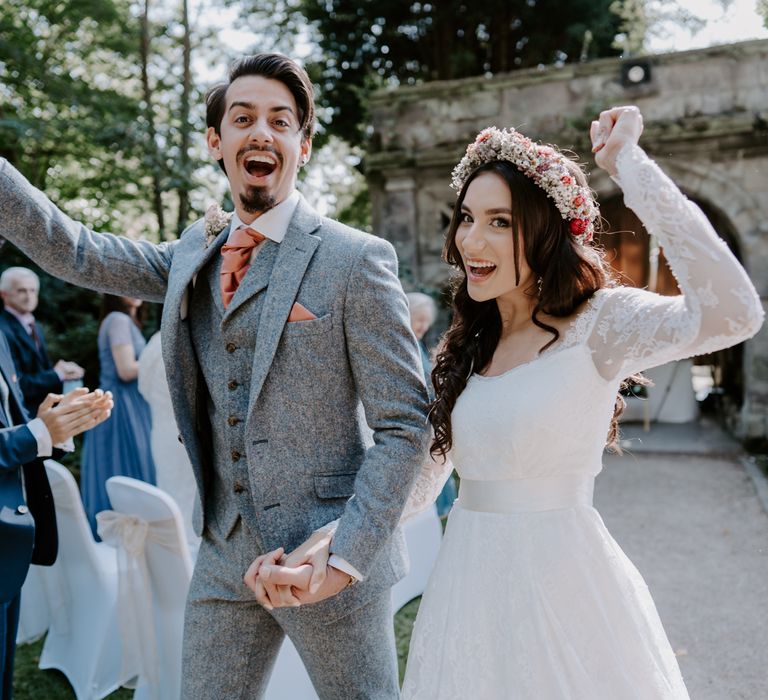 Bride and groom cheer through confetti shower