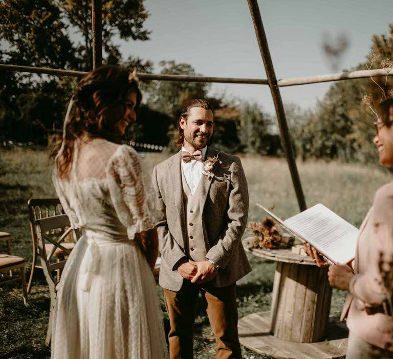 Bride and groom stand in front of the celebrant at their sustainable wedding