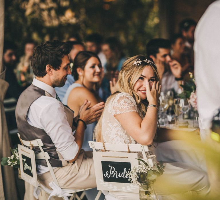 The bride smiles at her father's speech at family and friends wedding reception