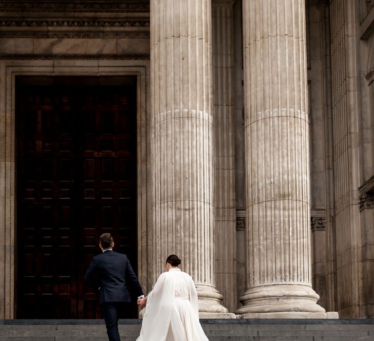 Portrait of the bride and groom on the steps of St Paul's Cathedral 