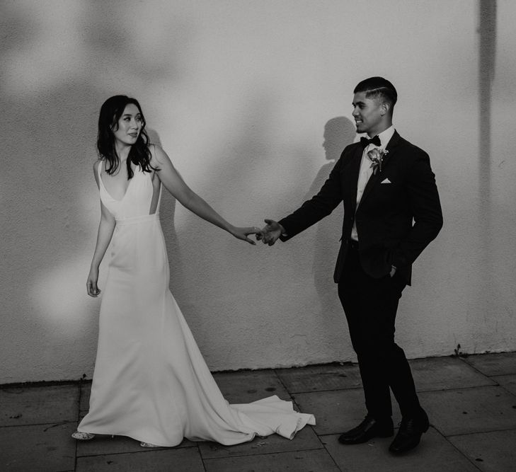 Black and white portrait of the bride and groom holding hands at their Core Clapton wedding by Elena Popa Photography