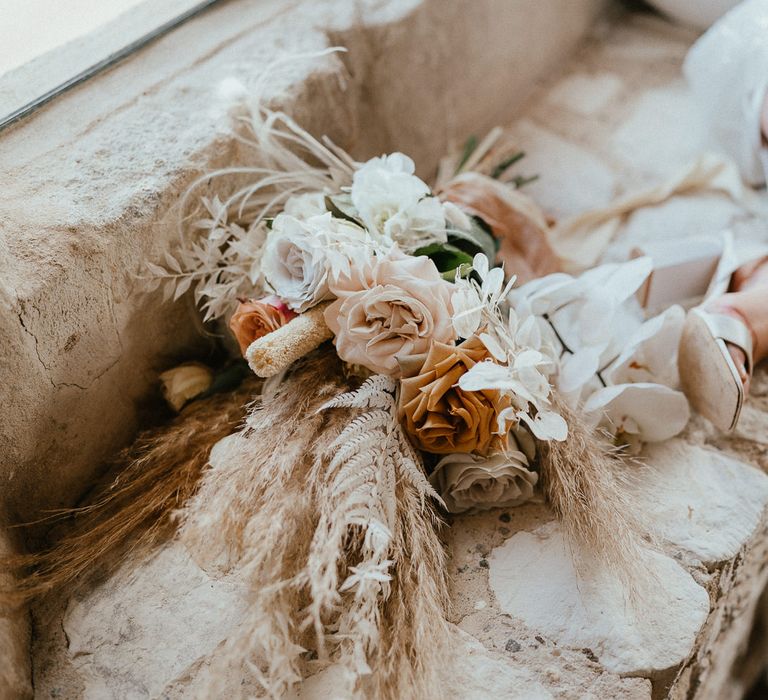 Dried and fresh wedding bouquet with orchids, twisted willow and frilly caramel-toned garden roses