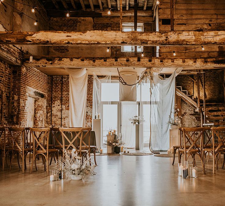 Bohemian luxury wedding ceremony at Godwick Great Hall and Barn with drapes, ropes, rugs and dried flowers 