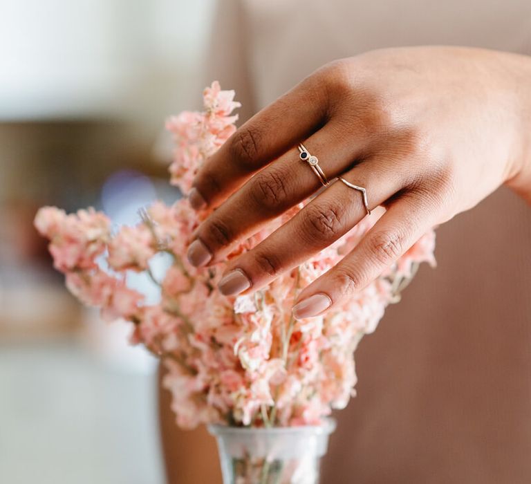 Woman wearing three wedding rings by Nikki Stark, including a ring with precious stones