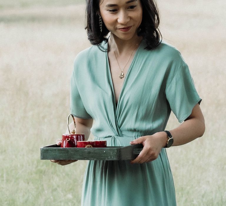 Bridesmaid wears boho chic sage green bridesmaid dress