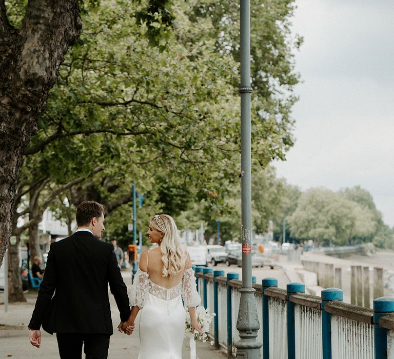 Bride with long wavy hair wearing a satin slip wedding dress with low back, and lace wedding train 