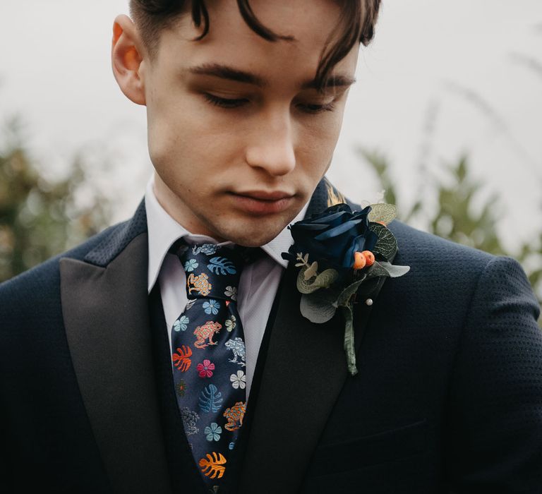 Groom in blue blazer with floral tie and blue floral buttonhole for Wellbeing Farm wedding