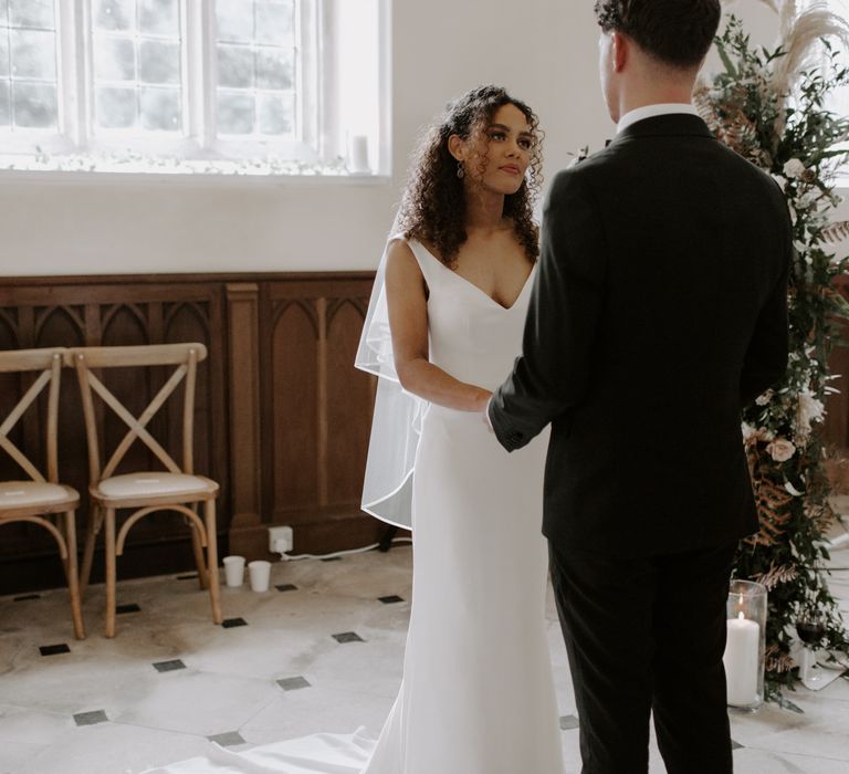 Bride looks lovingly at her groom during wedding ceremony 