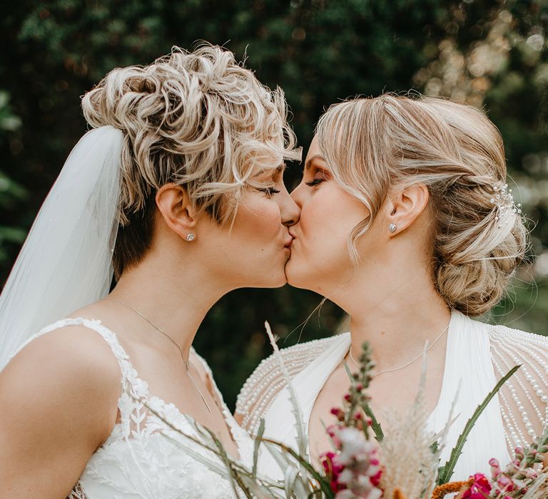 Brides kiss on their wedding day for lesbian wedding with pumpkin decorations 