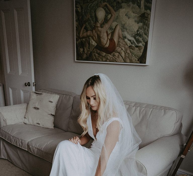 Bride slips on her Louboutin wedding shoes