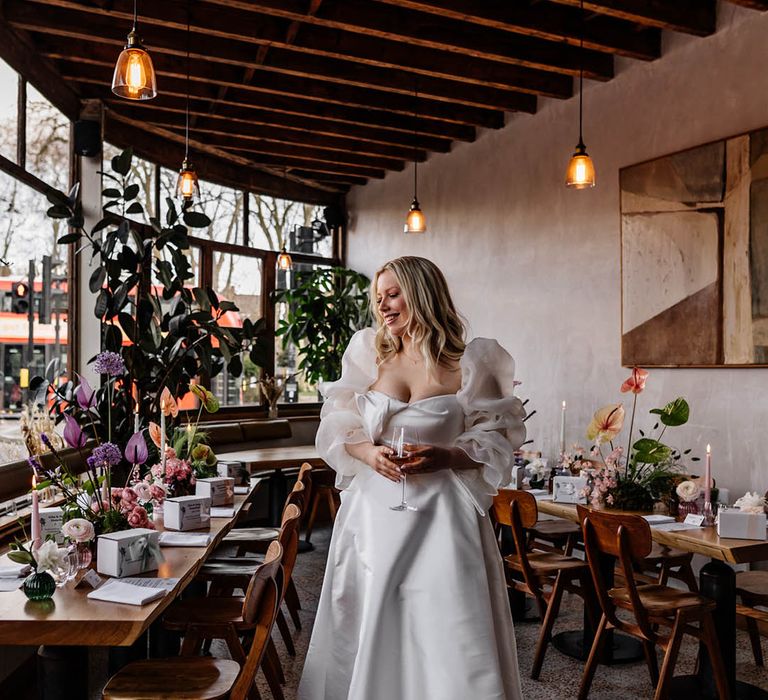 Florist bride in a Jesus Peiro wedding dress with sheer long voluminous sleeves standing in her wedding reception 