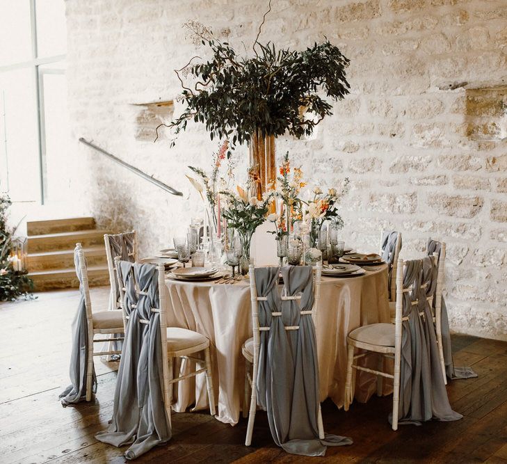 wedding reception table and chair back decor with drapes, flower centrepieces and taper candles 