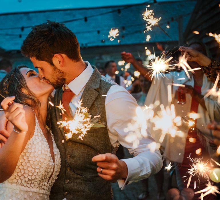 Bride and groom sharing a kiss at their sparkler send off at The Green Cornwall