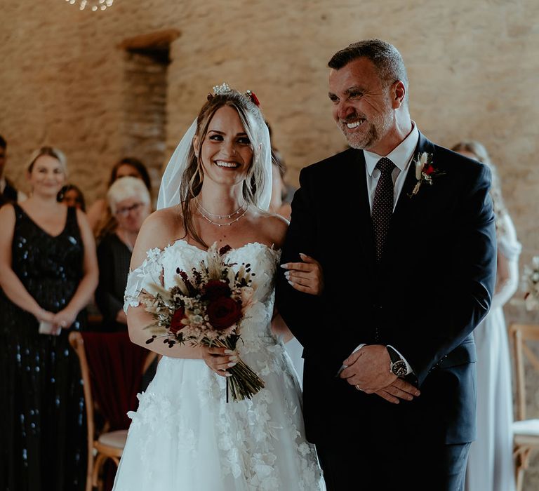 Father of the bride in navy wedding suit with rose and bunny grass buttonhole with bride in off the shoulder flower wedding dress