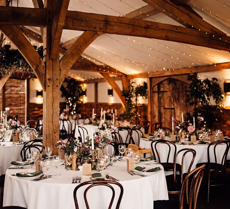 Cripps Barn wedding venue with fairy lights decorating the top of the venue and plenty of pink and purple flowers 