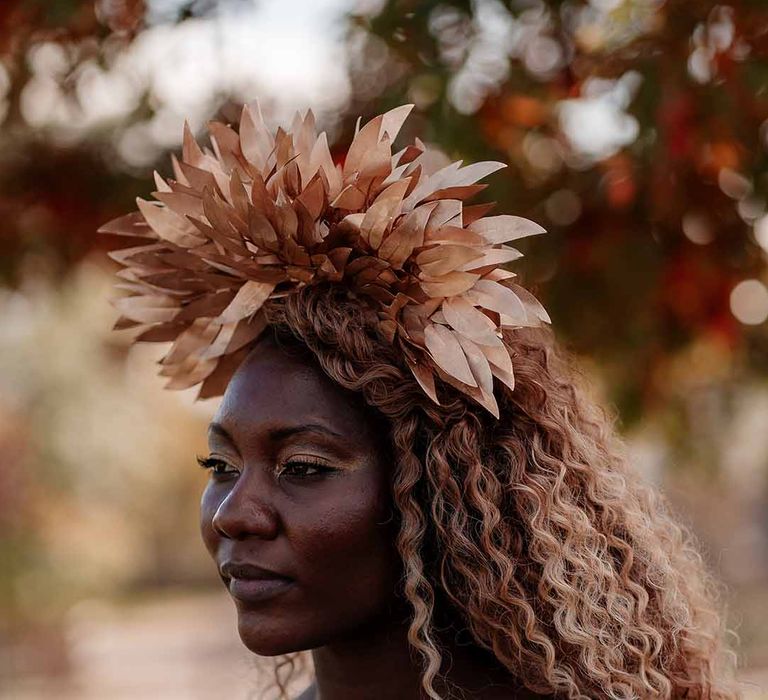 Bride with big, bold, golden eyeshadow and dewy lipstick wearing large golden leaf bridal crown