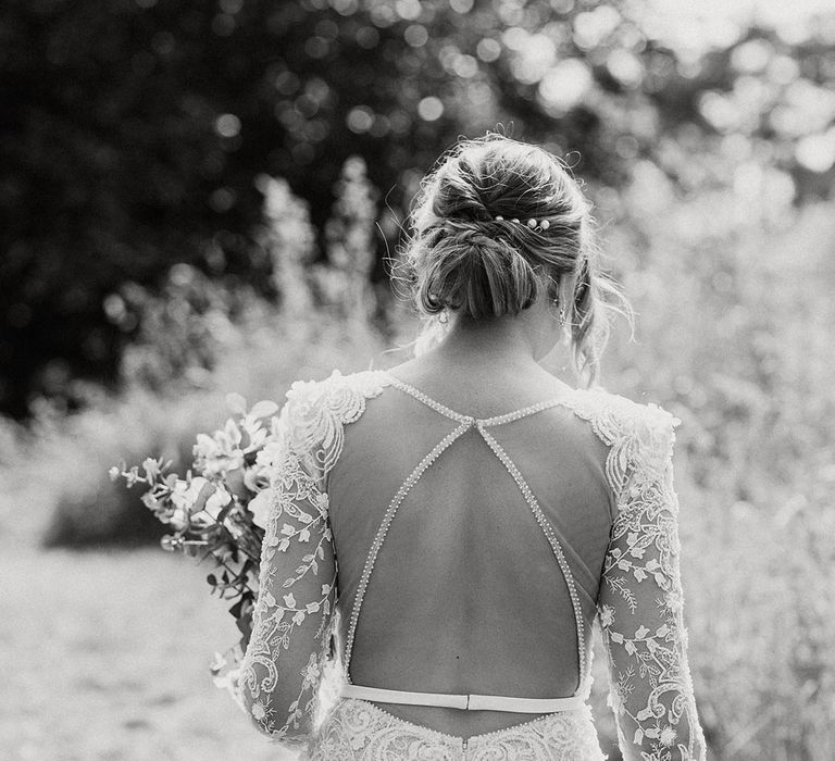 Bride in open back design with Wona NYC wedding dress with her hair in an updo with pearl clips 