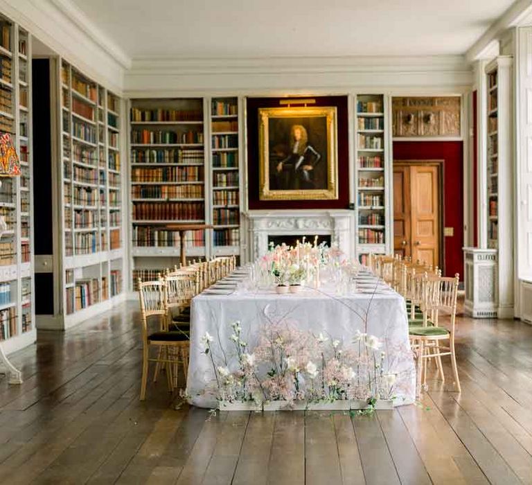 Classic wedding tablescape at St Giles House with pink tapered candles, white tablecloth and garden rose, peony, dried flower and baby's-breath spring flower arrangements in the reception room