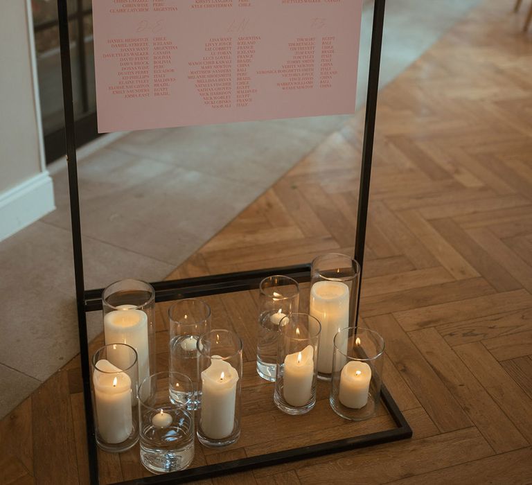 Pink and white wedding seating plan for the country house hotel wedding in Wiltshire with pillar candle decorations