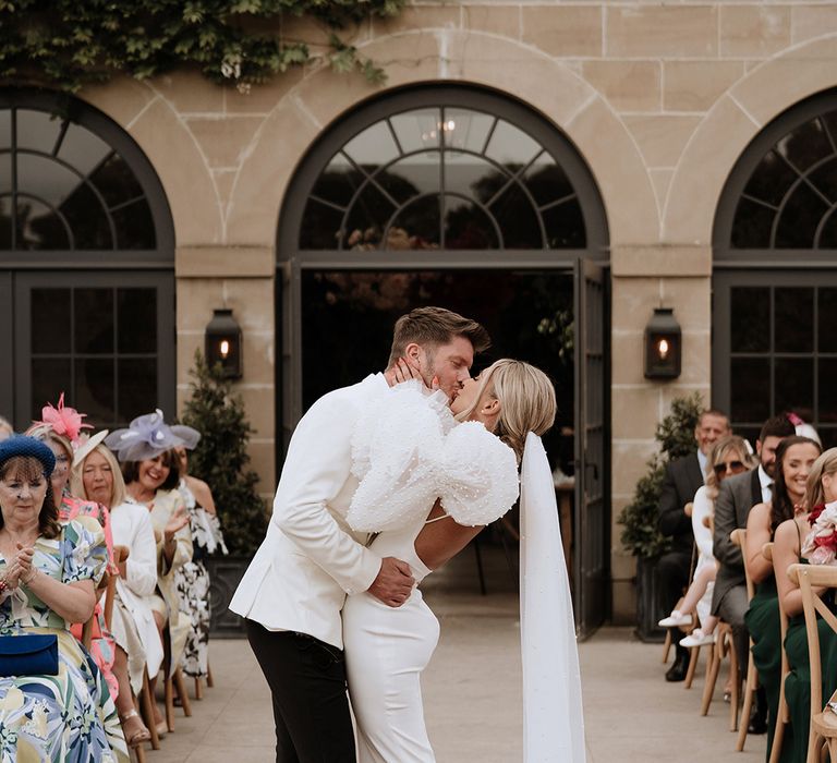 The bride and groom share their first kiss as a married couple at Middleton Lodge country house wedding venue 