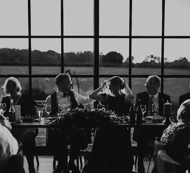 Botley Hill Barn in Surrey wedding venue with the groom helping the bride with her veil 