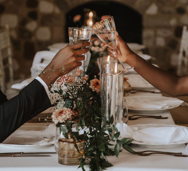 The bride and groom cheers their glasses together for wedding toast