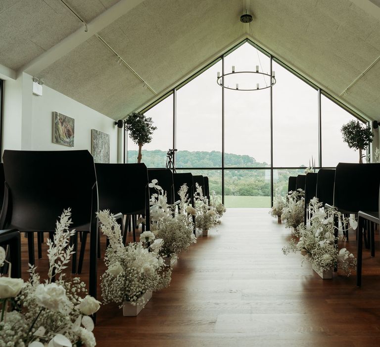 Crumplebury wedding venue with large window at altar and white flowers for wedding aisle decor