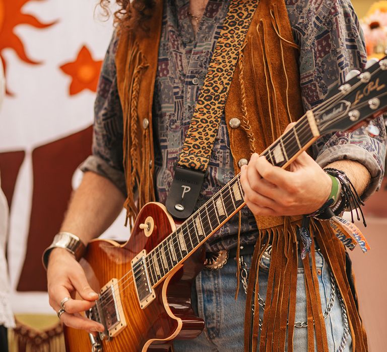 Musician in suede fringe jacket playing in a 60s wedding band to match The Daisy Jones & The Six