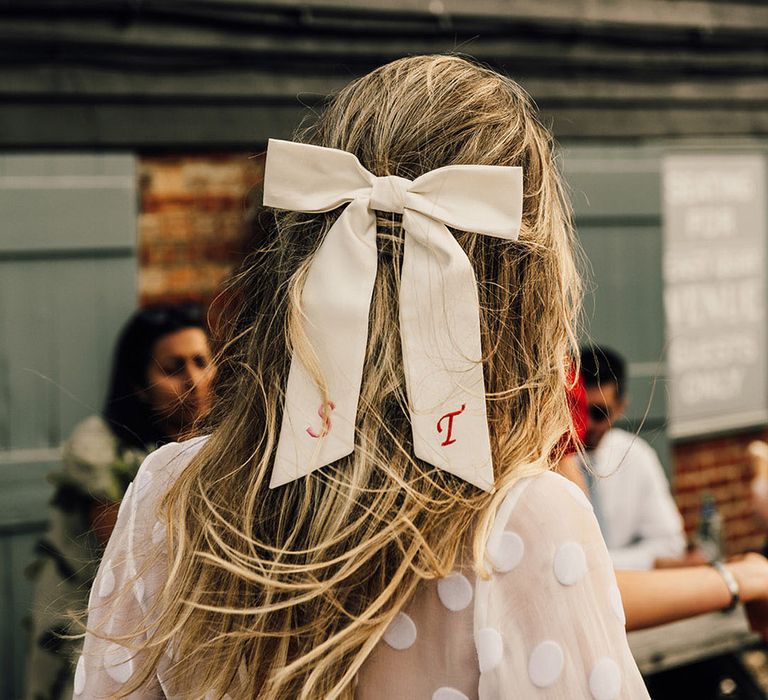 Bride wearing personalised hair bow accessory with custom embroidery 