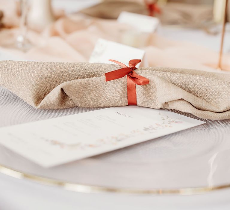 Napkin tied with orange ribbon for simple wedding place setting at autumn wedding 