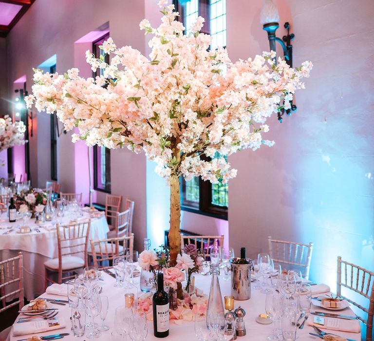 Blossom tree wedding table centrepieces with pink roses on round wedding tables 