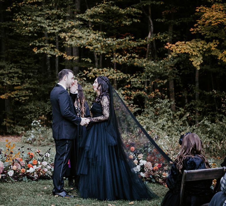 Bride wearing black wedding dress and veil for the outdoor gothic wedding in New York 