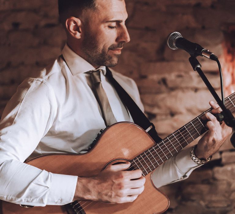 Wedding singer plays at the wedding ceremony with acoustic guitar 