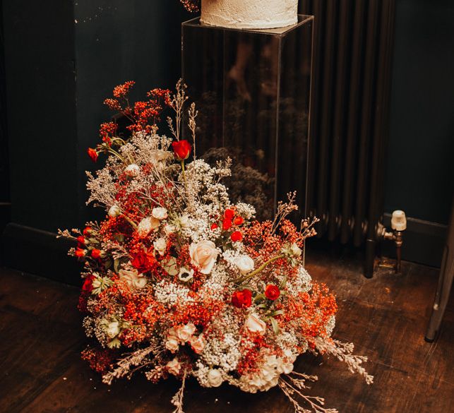 Four tier wedding cake with red floral installation