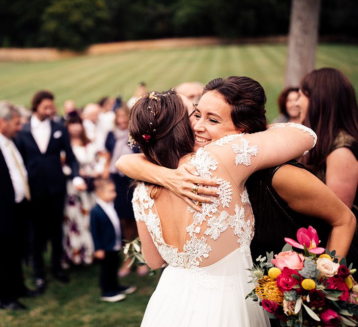 Bride in lace dress greets guests