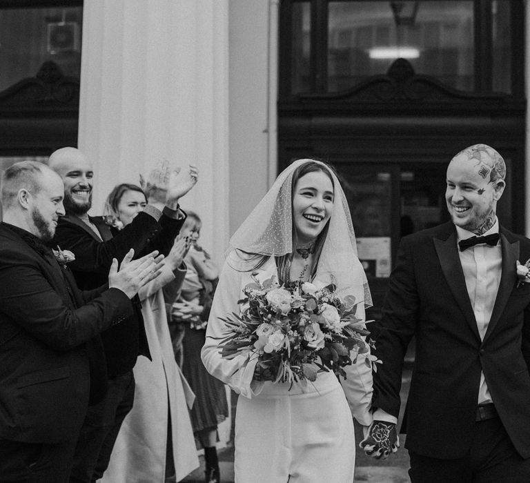 black and white portrait of bride and groom exiting the wedding ceremony 