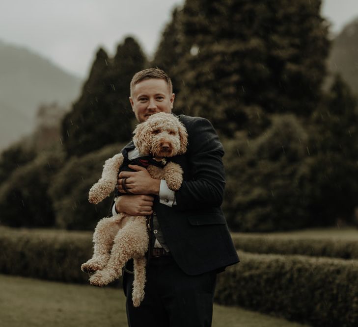 Groom in the rain with his dog at Winter Lake District Wedding