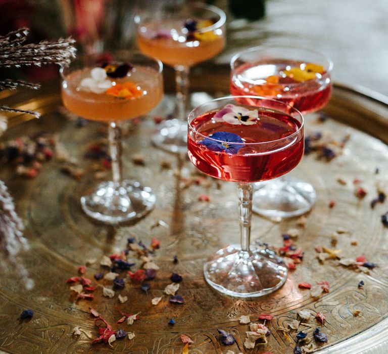 Platter of colourful cocktails filled with edible flowers 