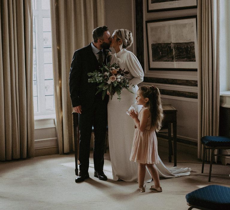 Bride and groom kissing at intimate wedding ceremony 